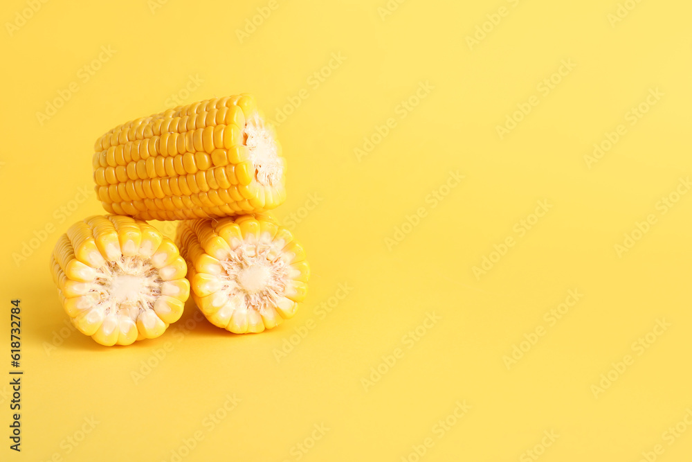 Cut fresh corn cobs on yellow background