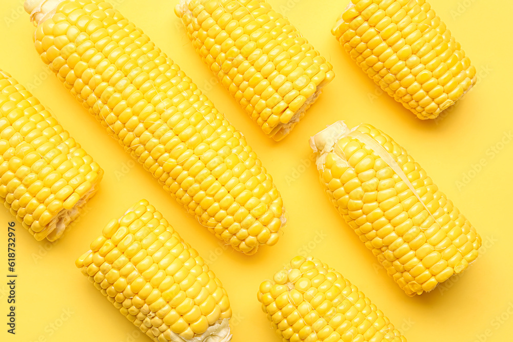 Fresh corn cobs on yellow background