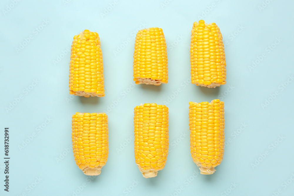 Cut fresh corn cobs on blue background