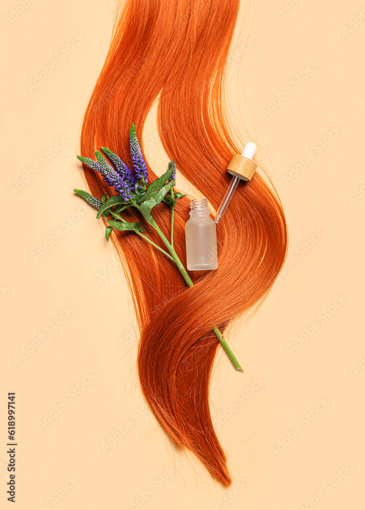 Ginger hair strand, flowers and bottle of essential oil on color background