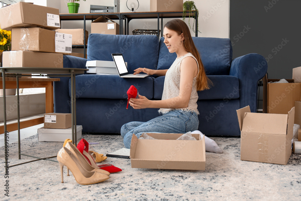 Young woman with new shoes using laptop at home