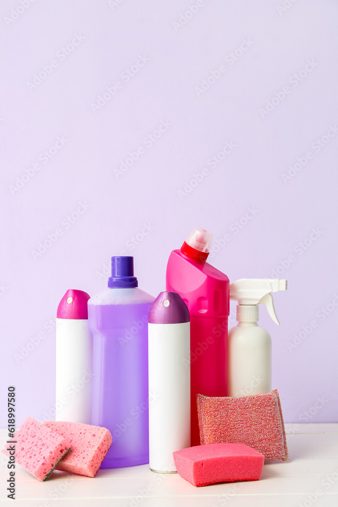 Different cleaning supplies on light wooden table