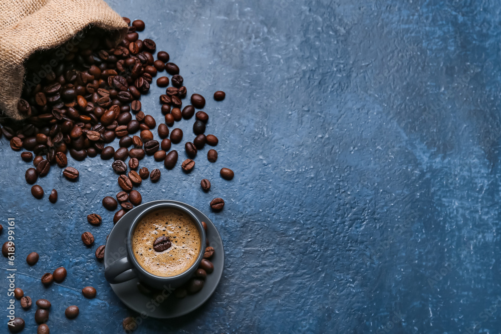 Cup of hot espresso and sack bag with coffee beans on blue background