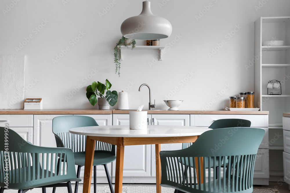 Interior of light kitchen with dining table and white counters