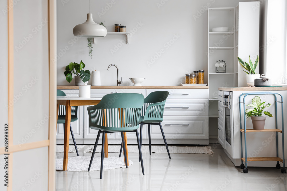 Interior of light kitchen with dining table and white counters