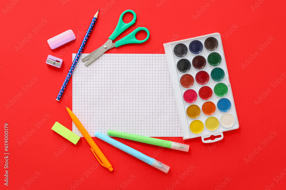 Blank notebook with different stationery on red background