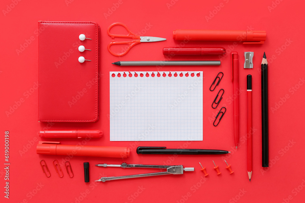 Blank notebook with different stationery on red background