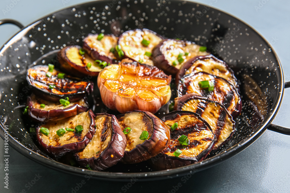 Wok with delicious grilled eggplants on grey background, closeup