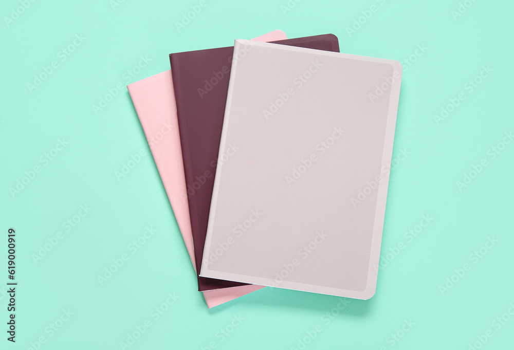 Different colorful notebooks on turquoise background