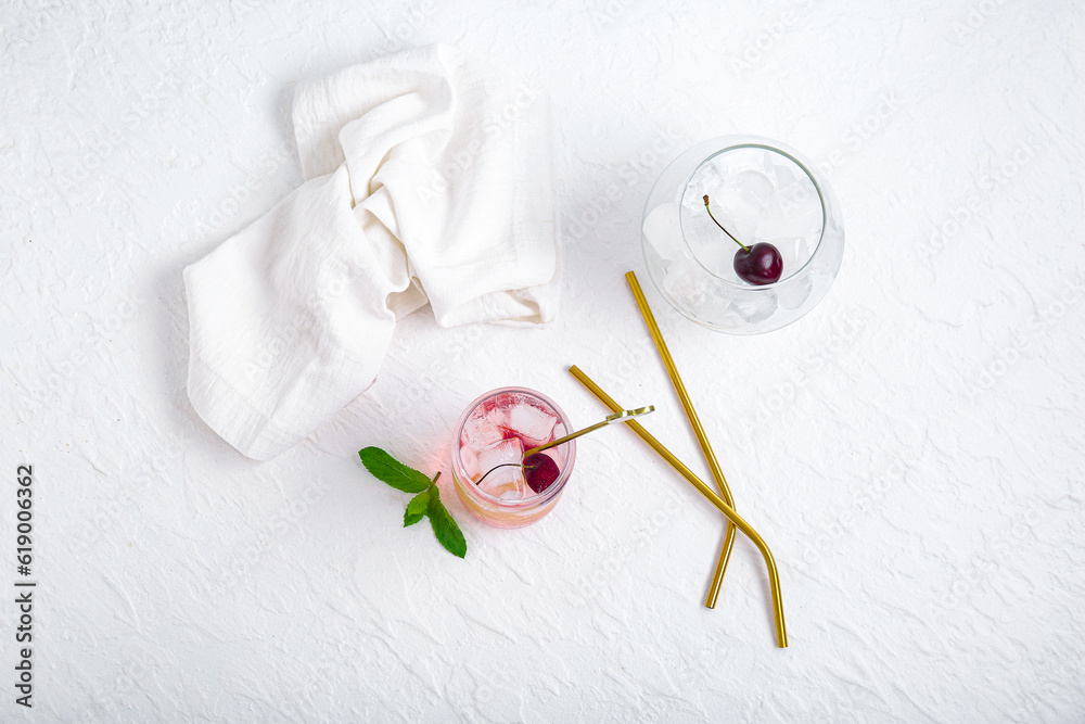 Glass of tasty cherry lemonade with mint on white background