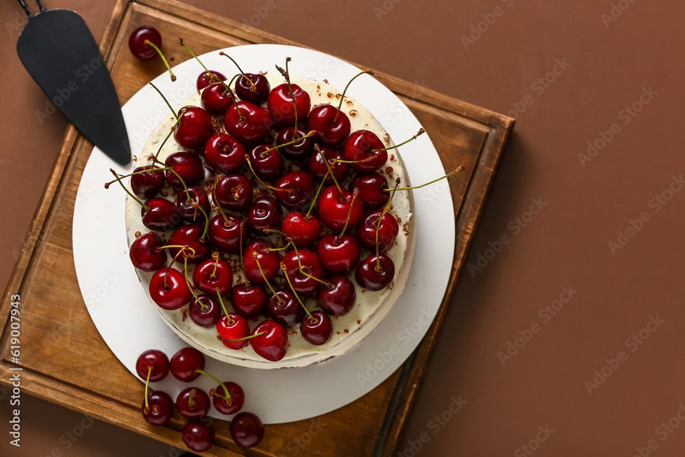 Wooden board with tasty cherry cake on red background