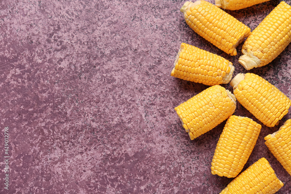 Cut fresh corn cobs on purple background