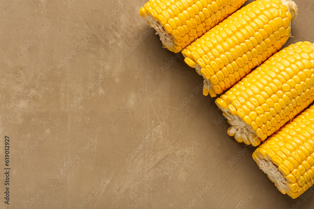 Cut fresh corn cobs on brown background