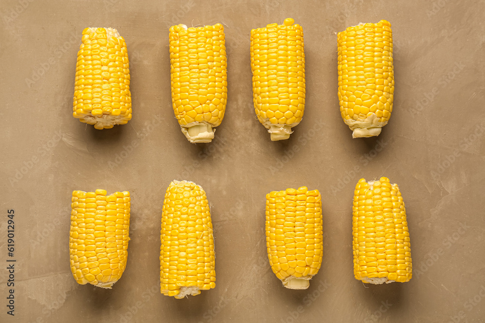 Cut fresh corn cobs on brown background