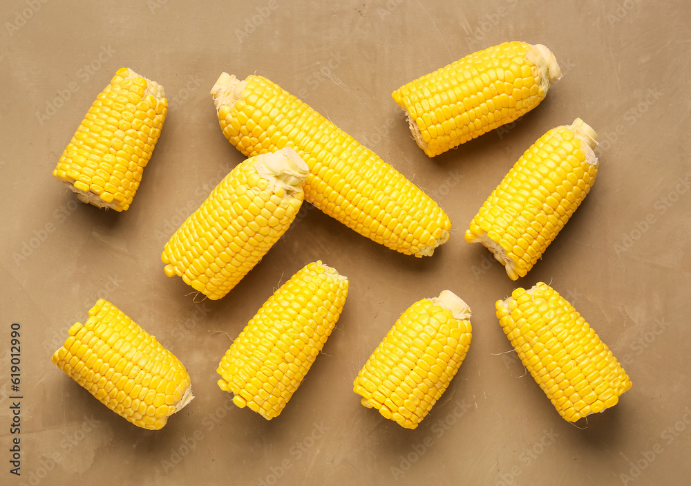 Fresh corn cobs on brown background