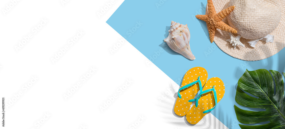 Summer concept with a straw hat, starfish, beach sandals and shell overhead view