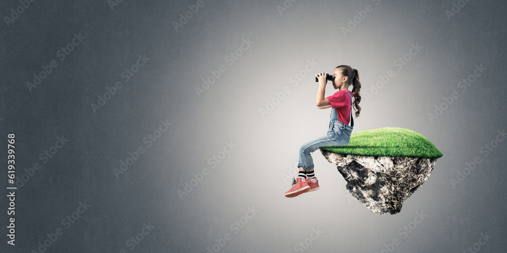 Concept of careless happy childhood with girl looking in binoculars