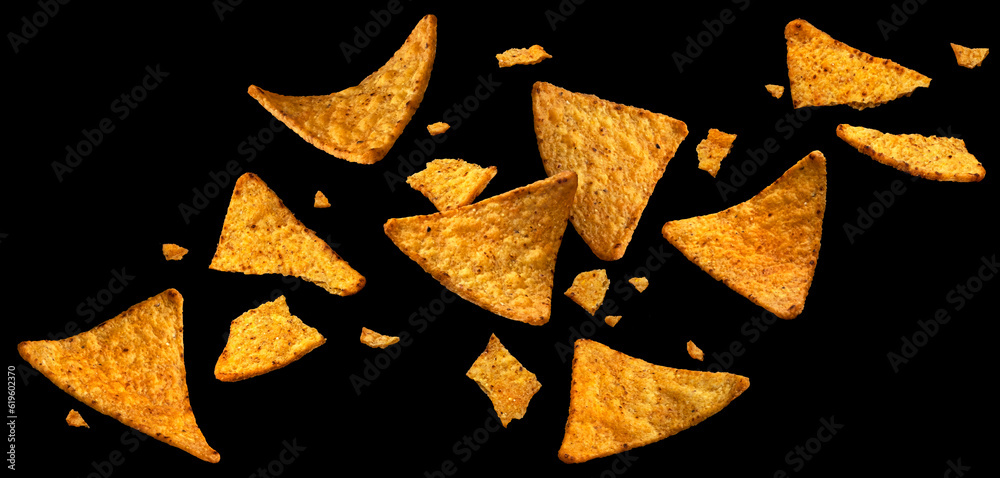 Falling corn chips, hot Mexican nachos isolated on black background