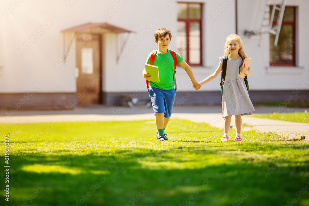 Boy and girl by holding hands going from school together.