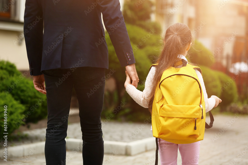 Little girl going to school with her father