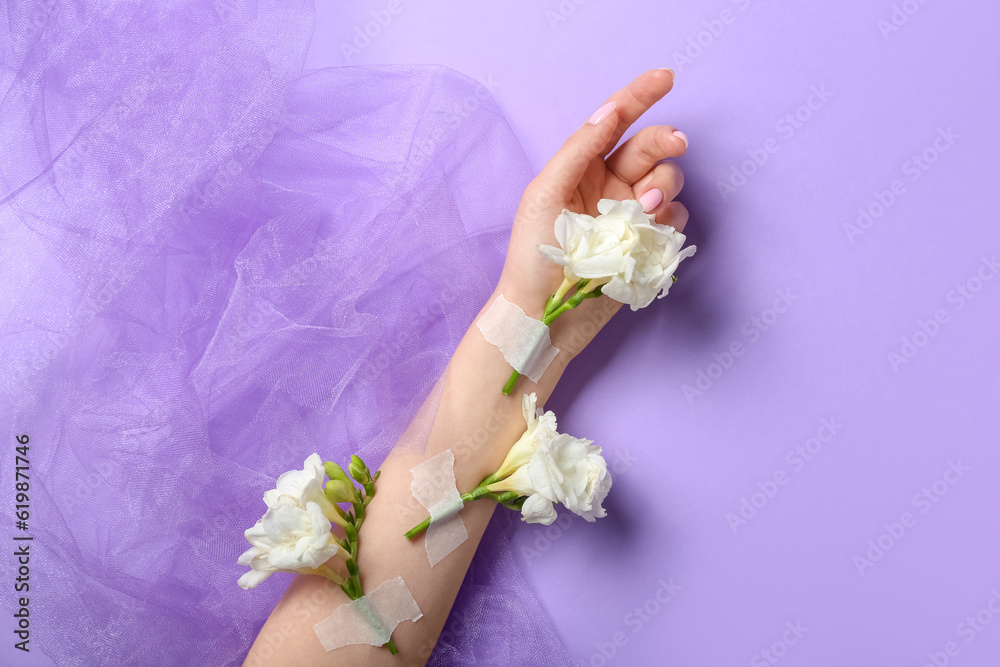 Woman with taped white flowers and veil on lilac background. Hand care concept