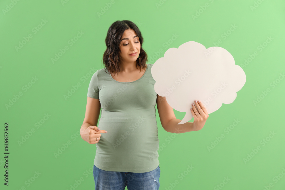 Young pregnant woman with blank speech bubble on green background