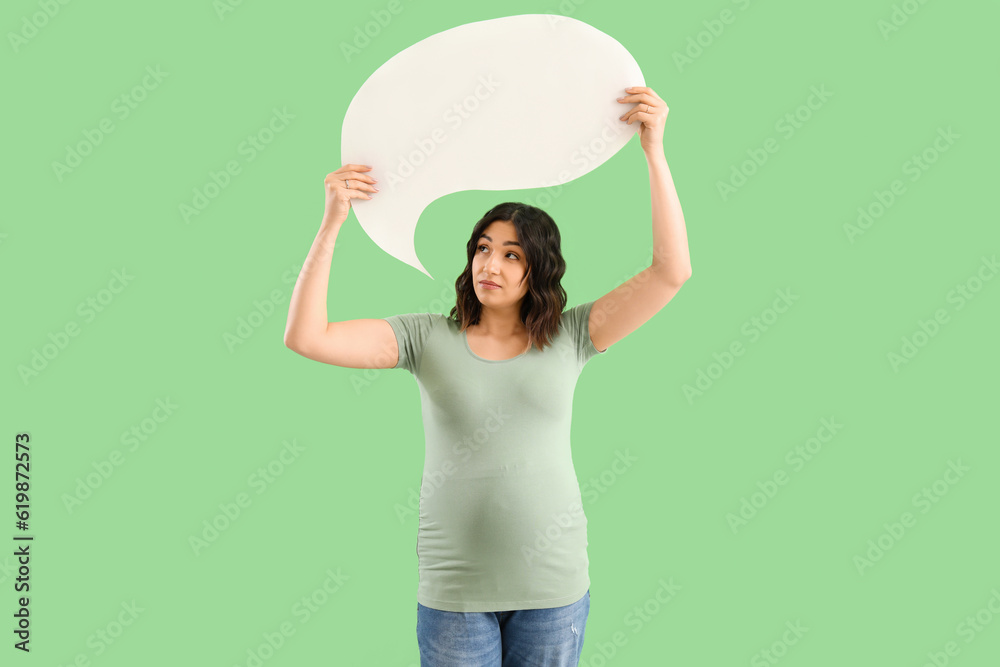 Young pregnant woman with blank speech bubble on green background