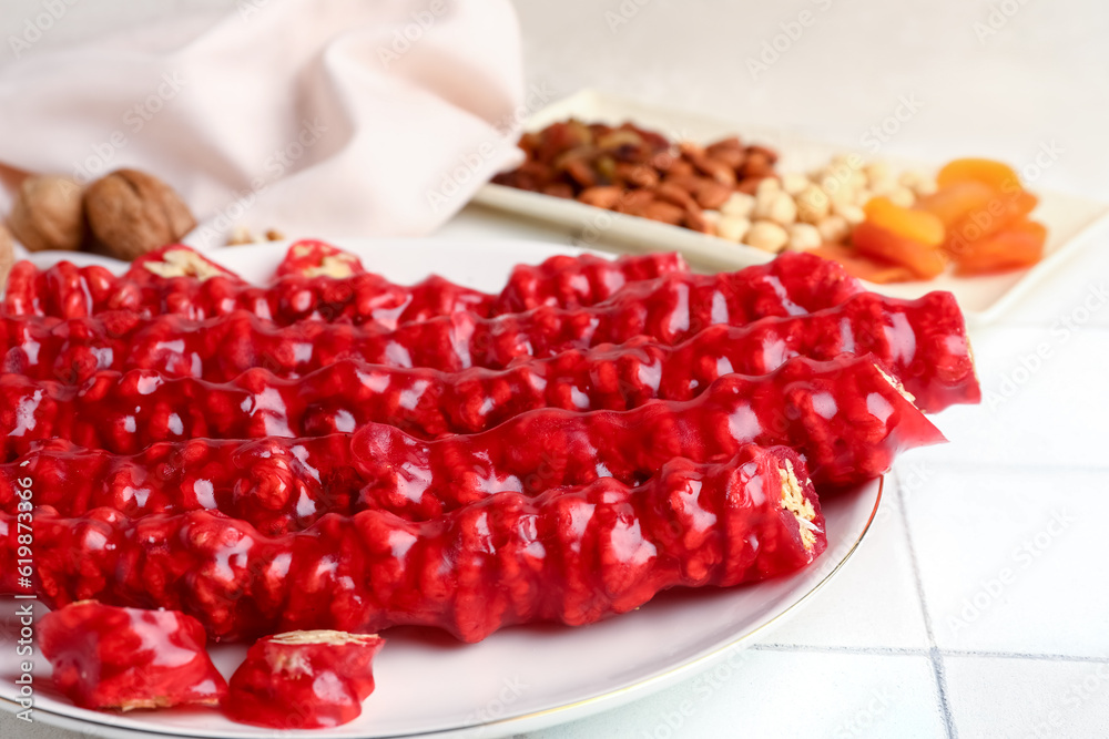 Plate with tasty churchkhela on table, closeup