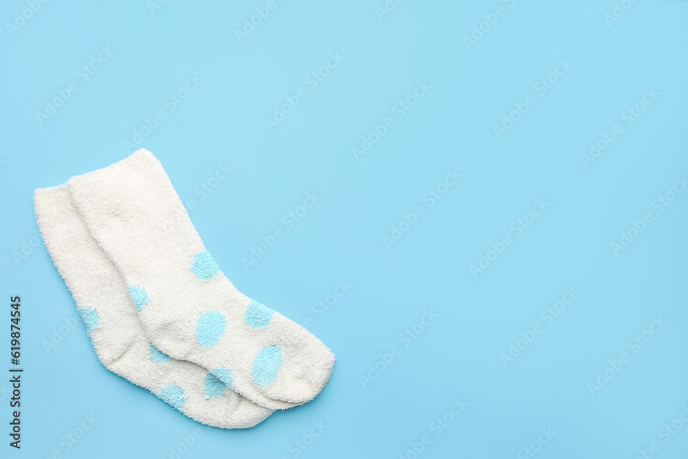 Pair of warm socks on color background