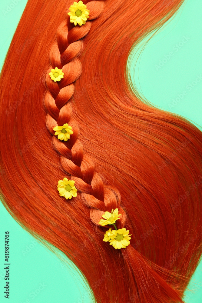 Ginger hair with braided strand and flowers on color background, closeup