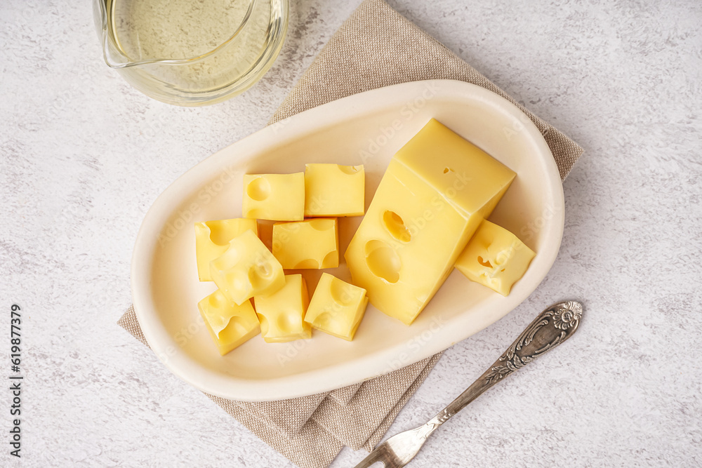 Plate with pieces of Swiss cheese on white table