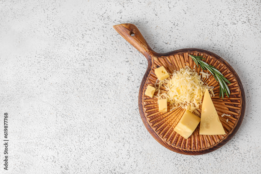 Wooden board with tasty Swiss cheese on light background