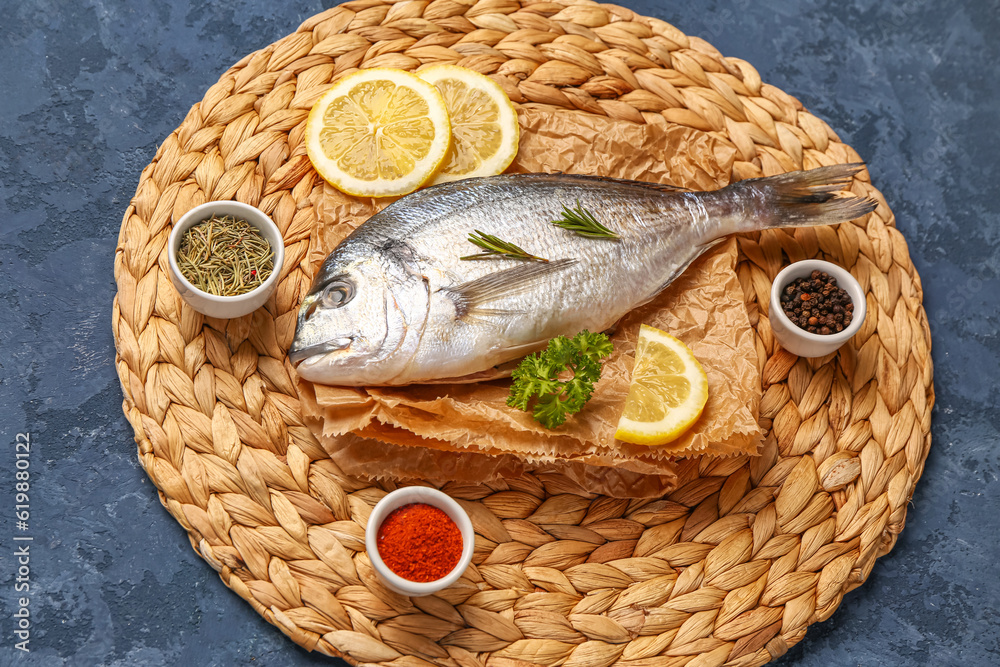 Raw dorado fish with lemon and spices on blue background