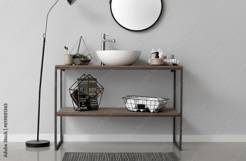 Table with sink bowl, bath accessories and mirror in bathroom