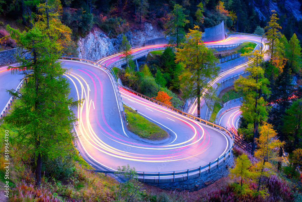 The mountain pass of Maloja, Switzerland. A road with many curves among the forest. Transportation. 