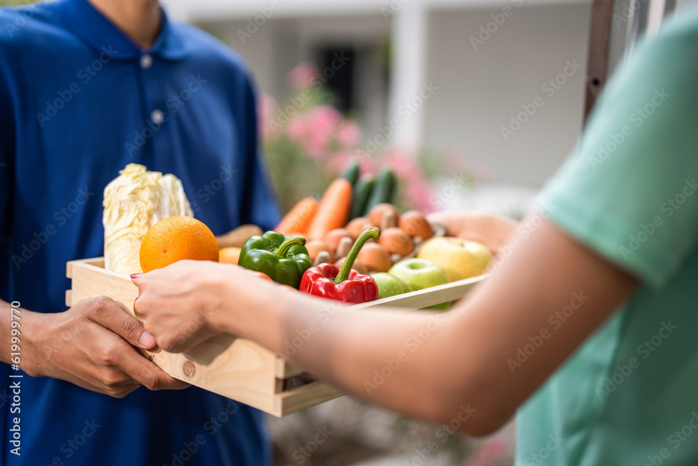 Close up of delivery man delivering package to female customer at home. 