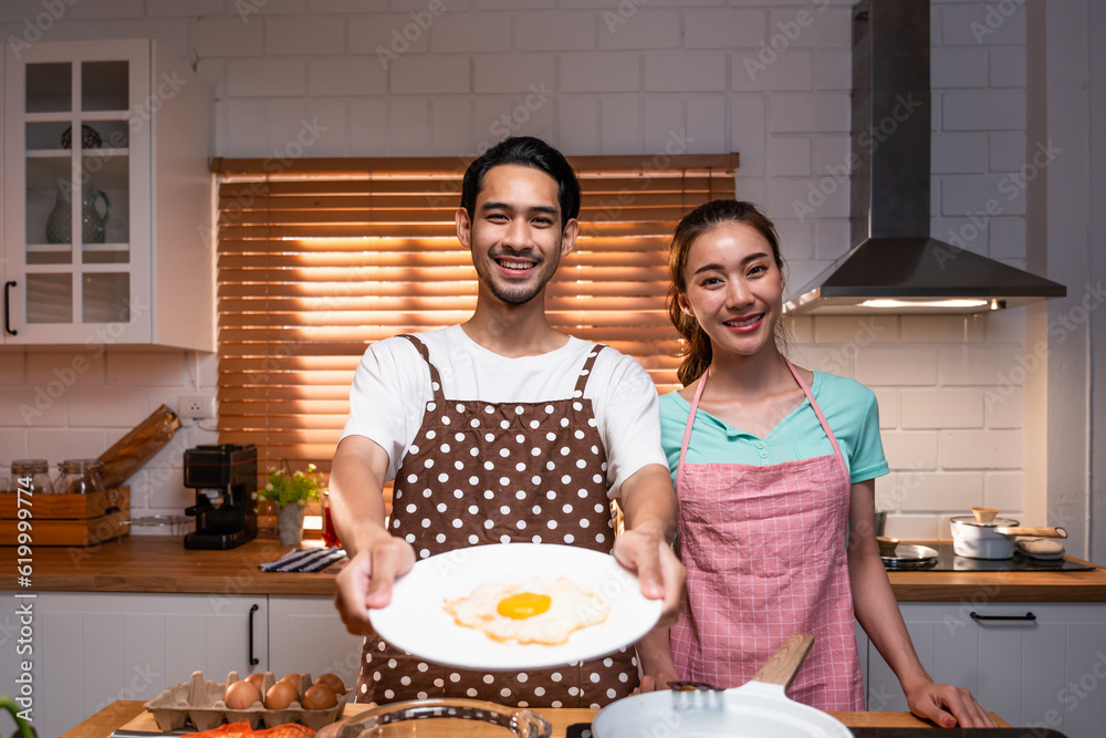 Portrait of Asian young couple spend time together in kitchen at home. 