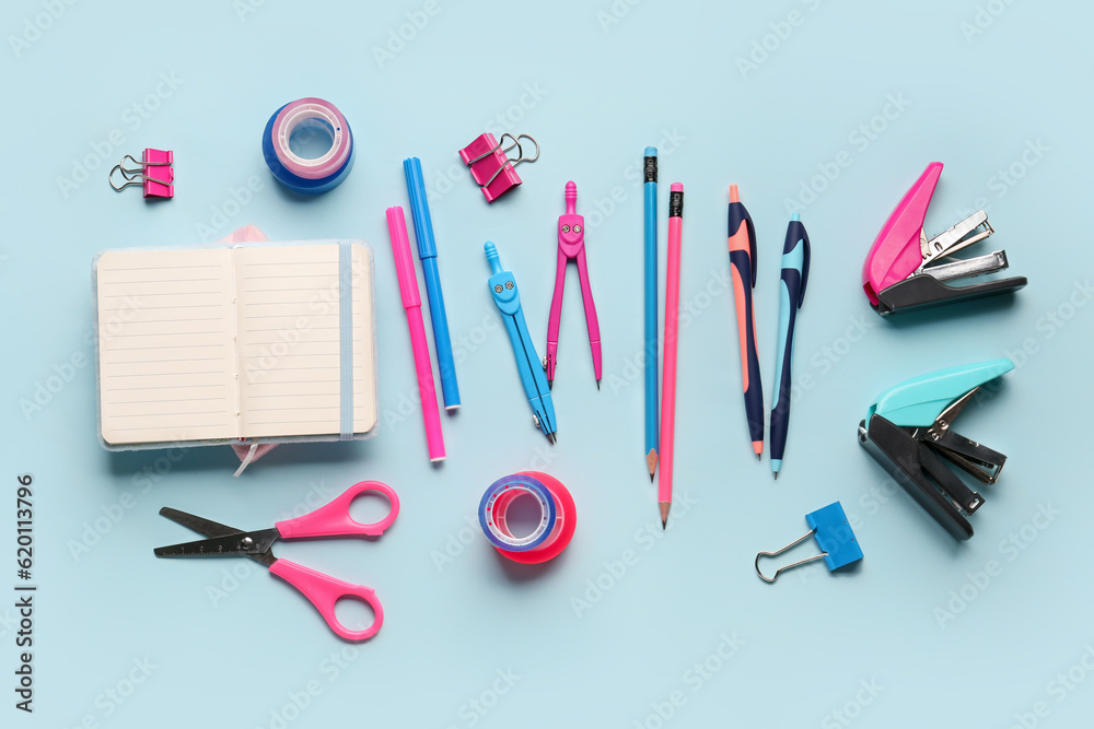 Composition with blank notebook and stationery supplies on blue background