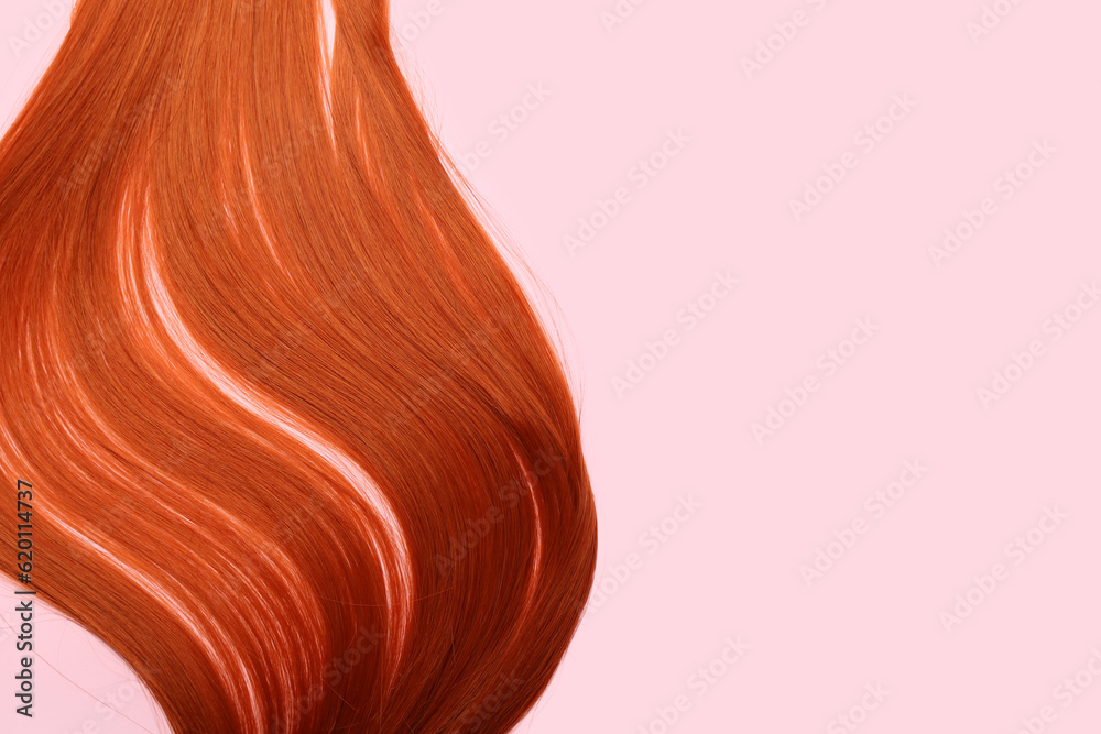 Ginger hair strand on pink background, closeup