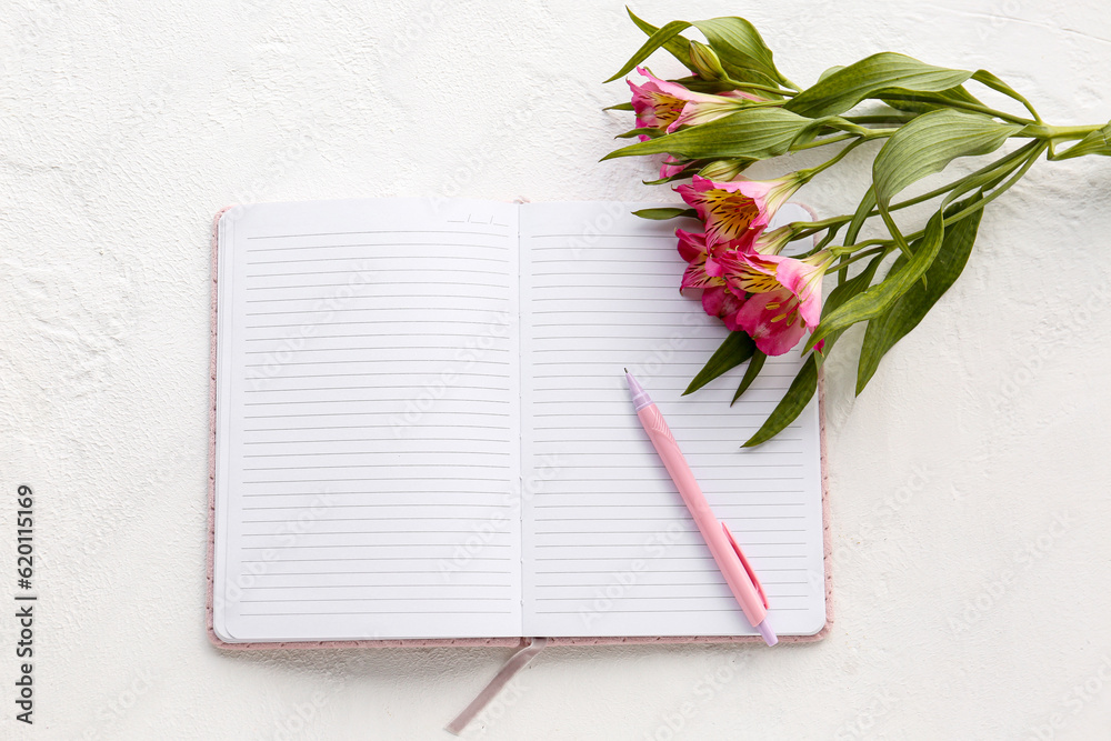 Blank open notebook with pen and alstroemeria flowers on light background