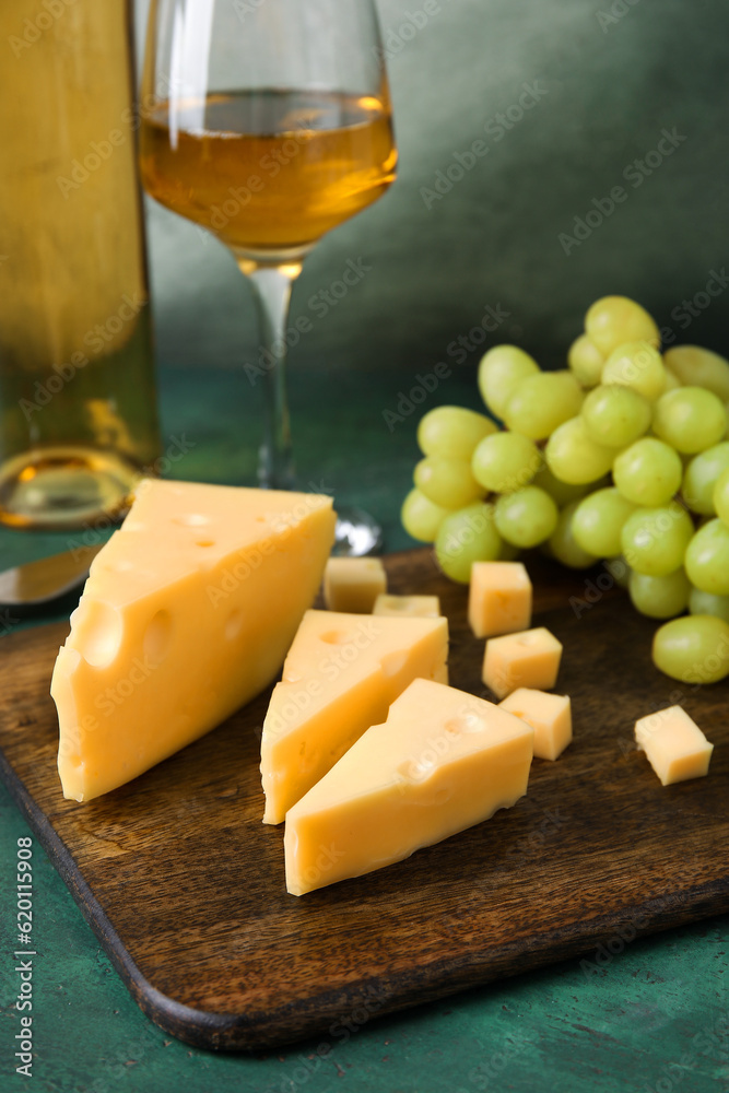 Wooden board with tasty Swiss cheese on table