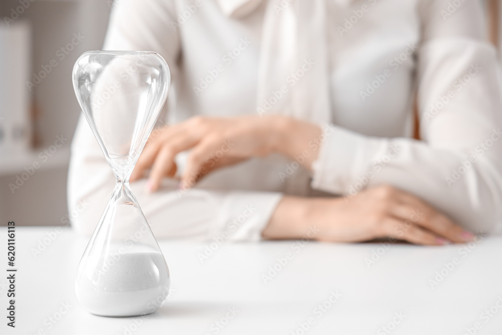 Hourglass on table in office.  Time management concept