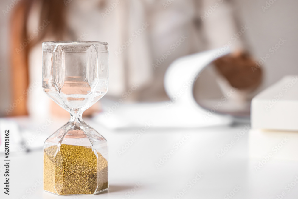 Hourglass on table in office.  Time management concept