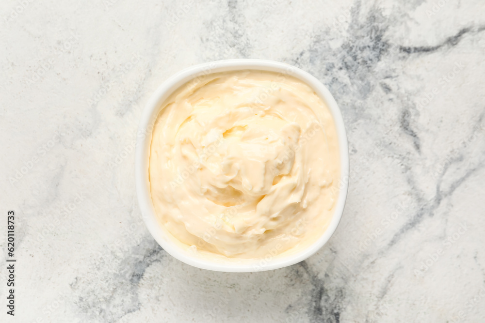 Bowl with tasty cream cheese on white marble background