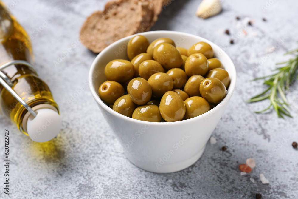 Bowl with ripe olives on light background