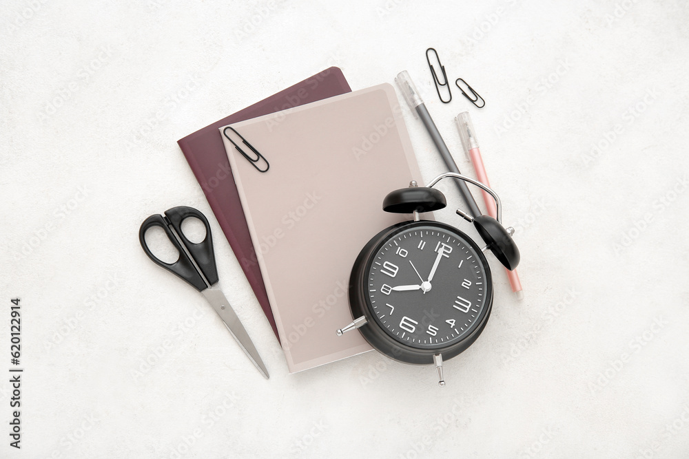 Alarm clock with different stationery on white background