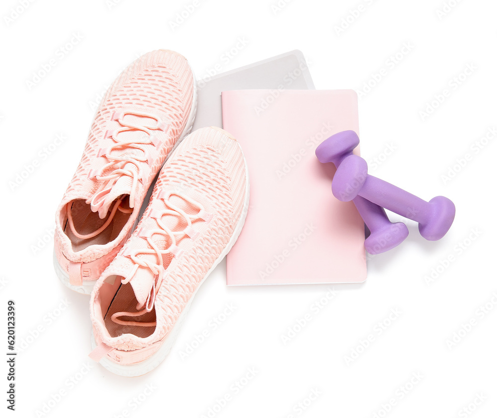 Notebooks with dumbbells and sneakers isolated on white background