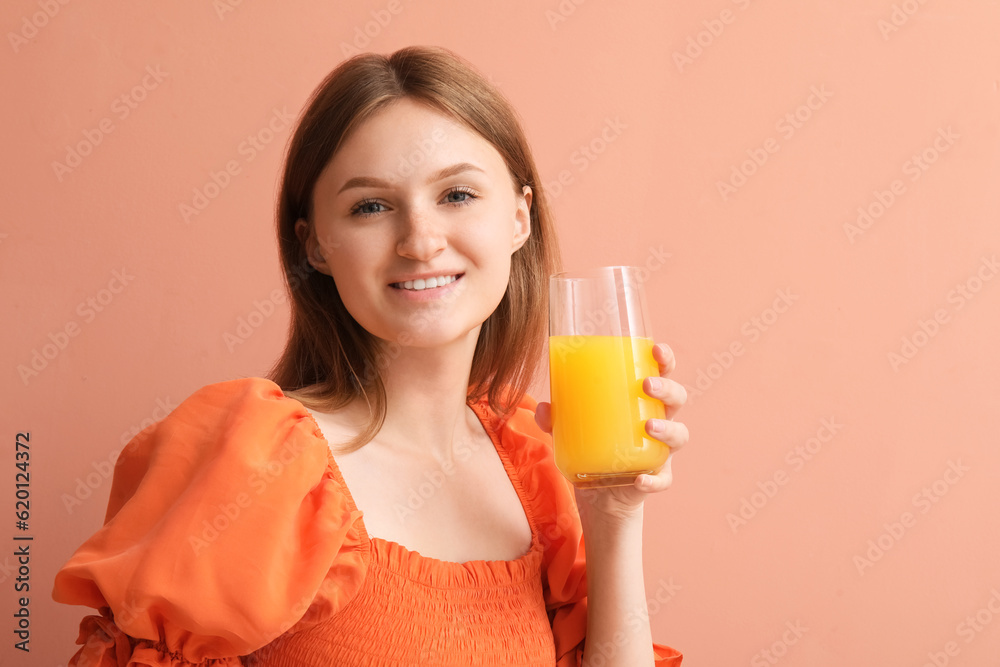 Teenage girl with glass of orange juice on pink background, closeup