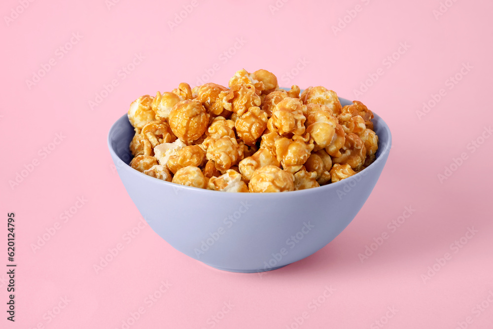 Bowl with tasty popcorn on pink background