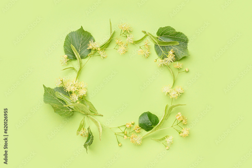 Frame made of fresh linden flowers and leaves on green background